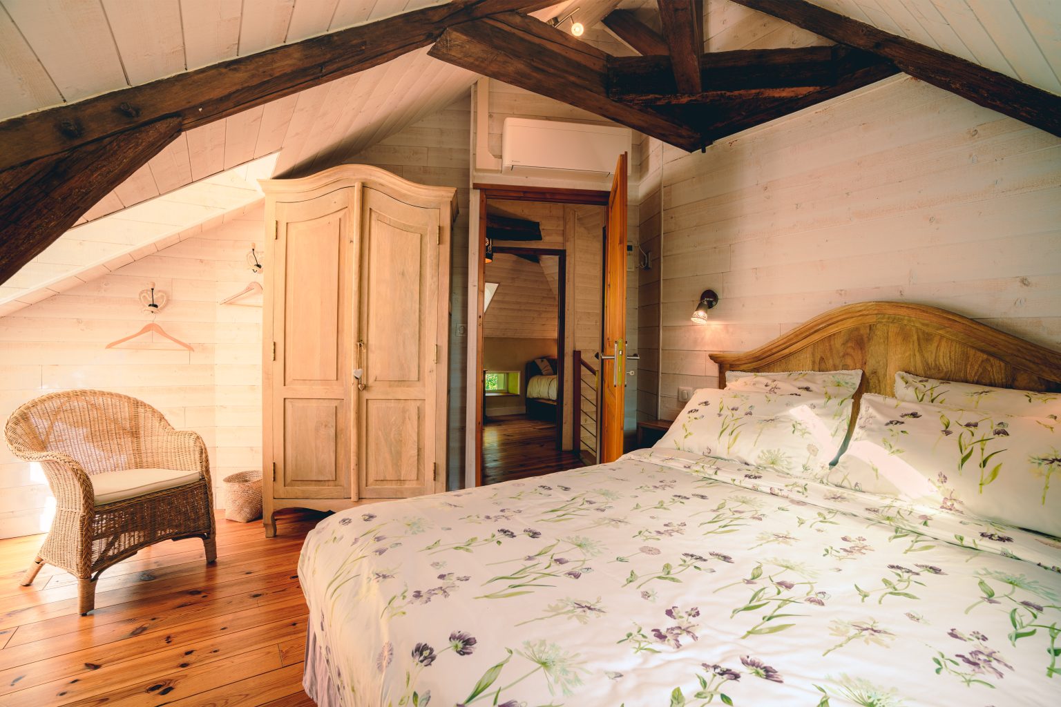 Chambre mansardee avec armoire et linge fleuri