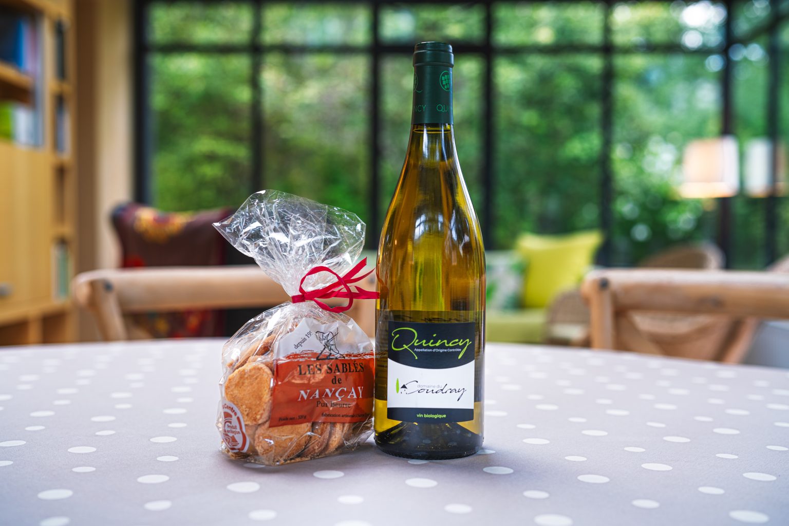 Detail d'accueil : bouteille de Quincy et sables sur la table de la veranda
