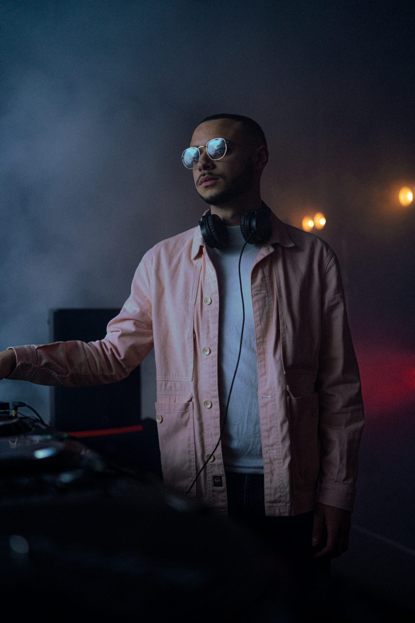 Portrait de DJ Nayr, lunettes et casque, fumee de scene
