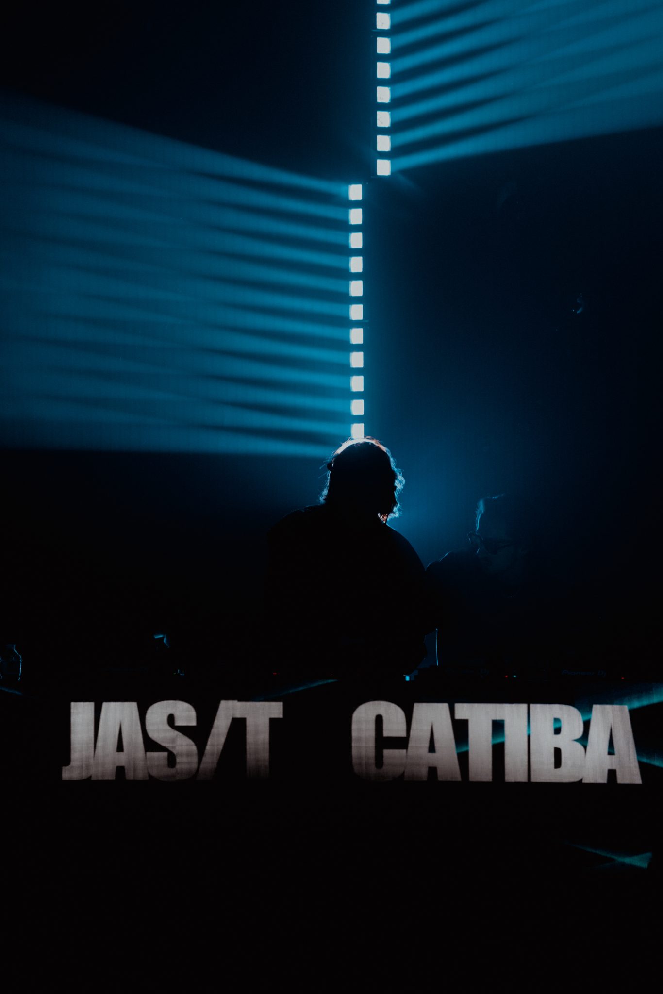 DJ sur scene et faisceaux lumineux bleus, live JAS/T & CATIBA