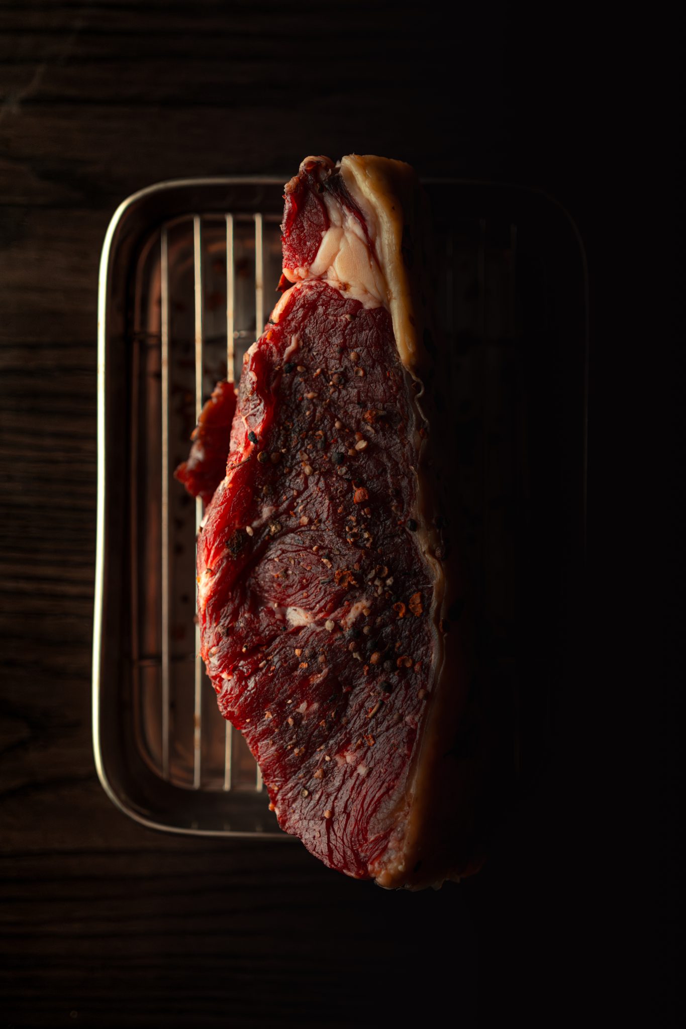 Piece de boeuf maturee sur grille, lumiere clair-obscur
