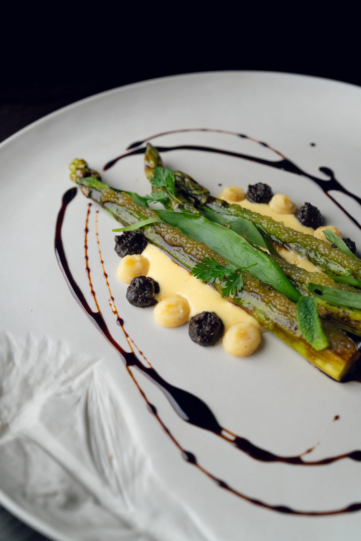Asperges vertes et condiments, dressage sur assiette blanche