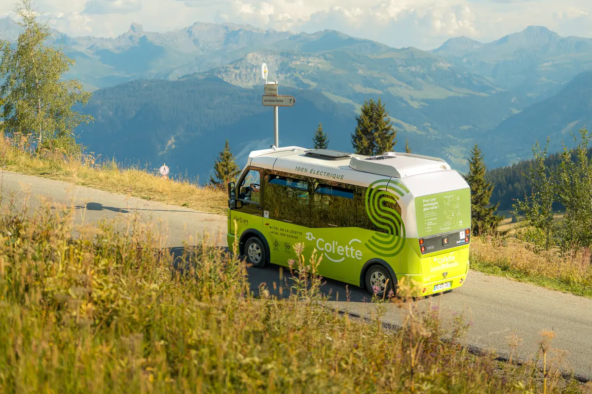 Navette verte de la station sur la route d'altitude, alpages et panorama de montagne derrière