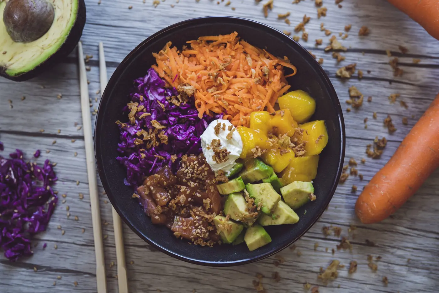 Bowl au chou rouge, carottes râpées, avocat et mangue, vu du dessus, carotte et avocat posés autour