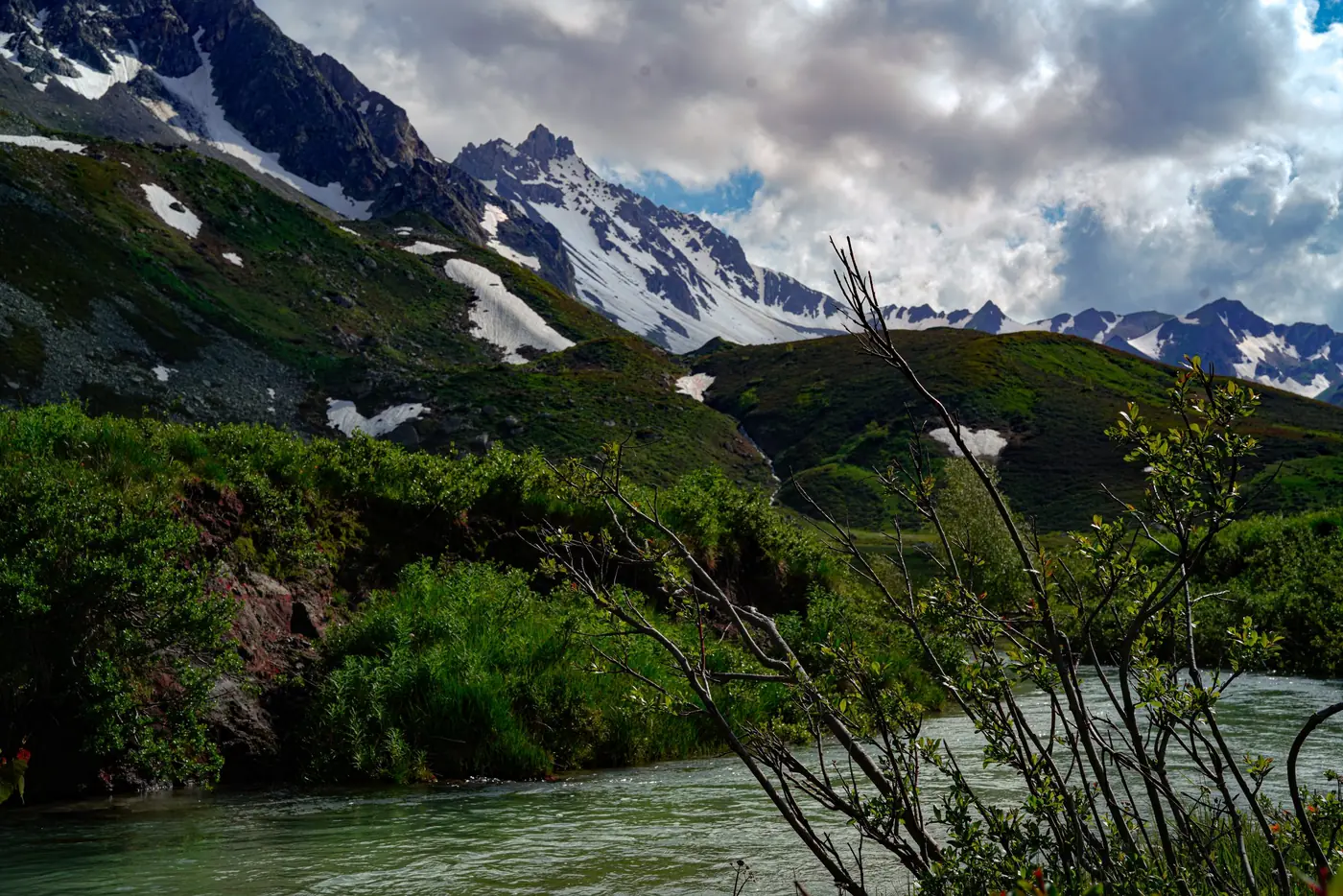 Torrent gonflé par la fonte des neiges près de Bourg-Saint-Maurice, versants verts et sommets enneigés