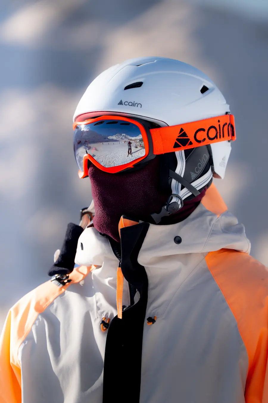 Gros plan d'un skieur au masque orange et cagoule bordeaux, Val Thorens