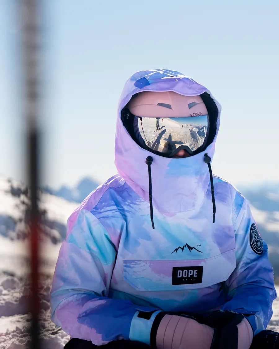 Skieuse au masque miroir et capuche pastel, portrait en station à Val Thorens