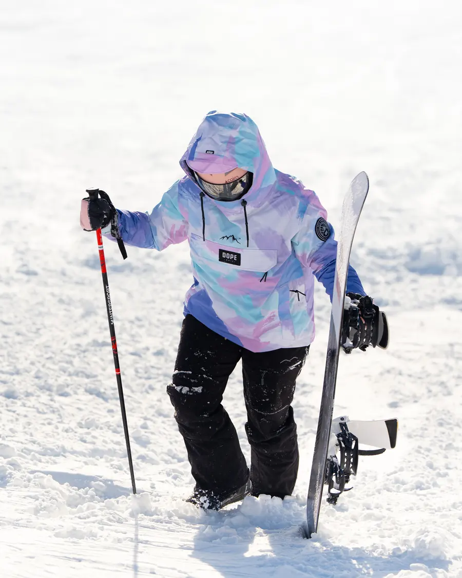 Skieuse qui remonte à pied dans la neige profonde, son matériel à la main, Val Thorens