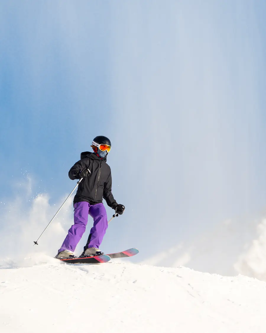 Snowboardeur qui soulève la neige dans un virage sur une pente de Val Thorens