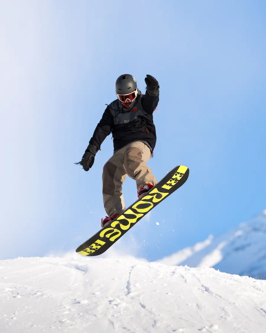 Snowboardeur en plein saut au-dessus d'une bosse, ciel bleu, Val Thorens