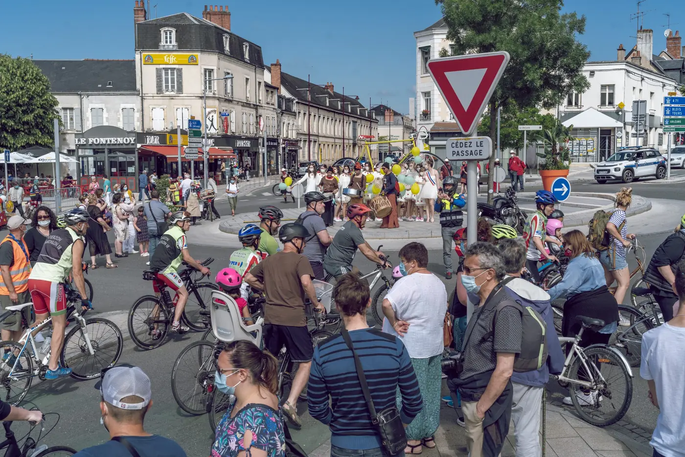 Foule et cyclistes amateurs massés dans une avenue de Vierzon le matin du départ