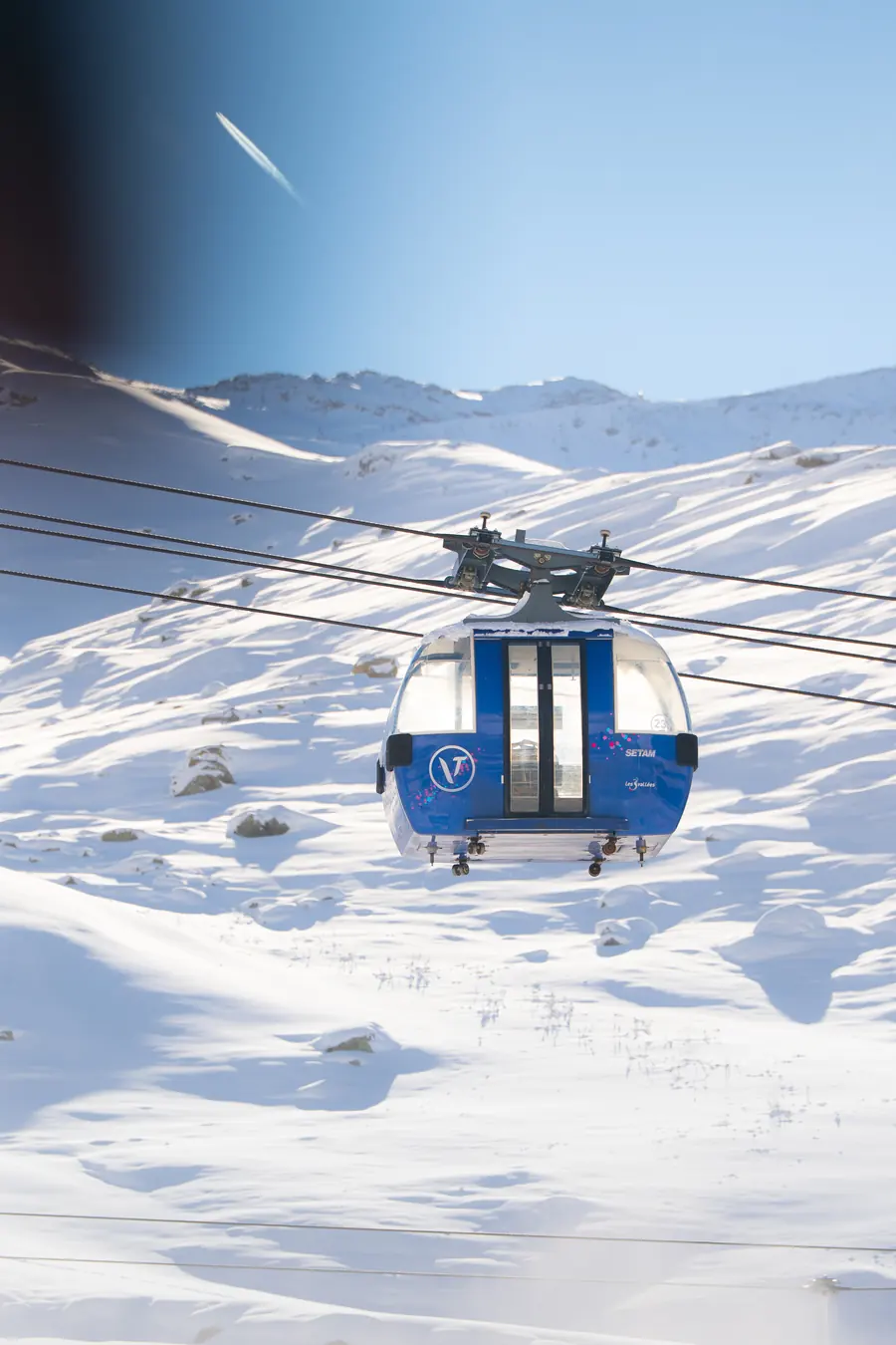 Télécabine de Val Thorens sur son câble, ciel bleu au-dessus des pistes